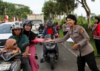 Polwan Bagikan Bendera Merah Putih di Depan Mapolda Kaltim