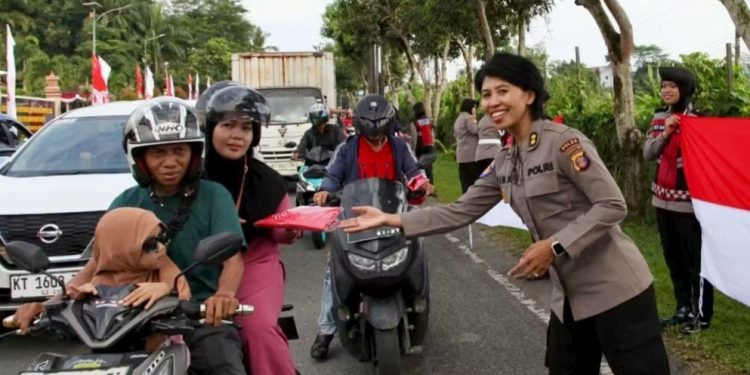 Polwan Bagikan Bendera Merah Putih di Depan Mapolda Kaltim